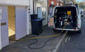 drainage engineer clearing blocked drains in aldershot outside residential property